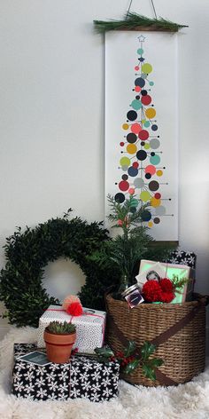 a basket filled with presents sitting on top of a white rug next to a christmas tree