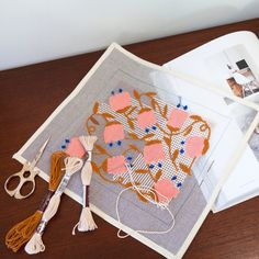 the table is covered with various crafting items including yarn, scissors and pictures on it