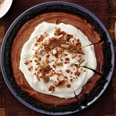 a chocolate pie topped with whipped cream and nuts