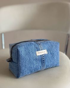 a denim pouch sitting on top of a white chair