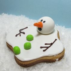 a frosted cookie with icing on top of it and a fake snowman