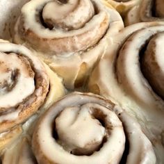 several cinnamon rolls with icing sitting on top of each other