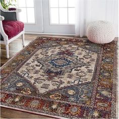 a large rug with an ornate design on the floor in front of a chair and window