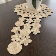 the table is covered with decorative doily and has a white vase on top of it