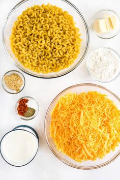 the ingredients to make macaroni and cheese are shown in bowls on a white surface