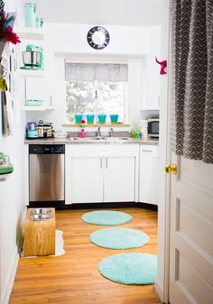 the kitchen is clean and ready to be used for cooking or baking, with blue rugs on the floor