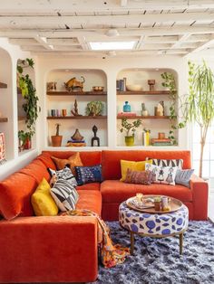 a living room filled with furniture and lots of shelves on the wall above it's couches