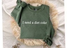 "I Need A Diet Coke Sweatshirt, Diet Coke Bottles, Gift for Diet Coke Lover, Soda Gift Crewneck, Funny Gift Sweatshirt Soda Lover, Funny Coke Size and Colors : - Check images for sizing details and color options. Measurement Notes: - Lay the garment flat. Width is measured 1\" below armhole at bust level. - Body length is measured from the back centerline seam to the underside of the front hem. Care Instructions: - Turn the garment inside out and wash cold on a delicate program. Lay flat to dry. - Do not bleach, dry clean or iron directly on the design. Processing time : - Standard processing is 1-3 business days before shipping your orders. For rush transaction, please visit the \"upgrade\" list and contact us before purchasing. Distribution time: - Standard shipping takes 3-6 days to del Diet Coke, Vinyl Ideas, Silhouette Projects, Dream Clothes, Shirt Ideas, Cuff Sleeves, Cricut Projects, Types Of Shirts, Comfort Colors