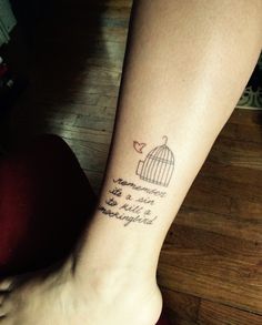 a woman's foot with a bird in a cage tattoo on her left ankle