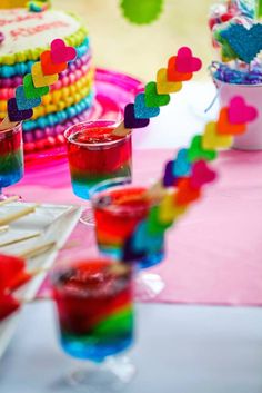 colorful desserts and drinks on a table with paper hearts sticking out of the cups