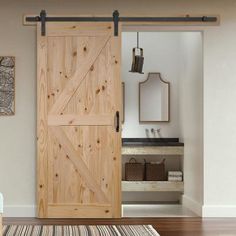 an open wooden door in a living room next to a rug and mirror on the wall