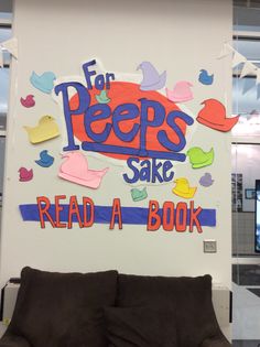 a couch sitting in front of a sign that says for pees sake read a book