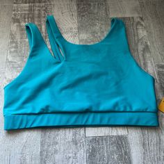 Size Large Sleeveless Solid Activewear For Beach, Sleeveless Solid Activewear For The Beach, Sporty Sports Bra For The Beach, Blue Racerback Swimwear For Training, Blue Racerback Training Swimwear, Sporty Racerback Crop Top For Beach, Sporty Light Blue Swimwear For Active Use, Sporty Light Blue Swimwear For Sports, Blue Beach Activewear With Built-in Bra