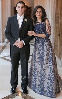 a man and woman in formal wear posing for a photo