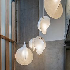 three white lights hanging from the ceiling in a room with concrete walls and flooring