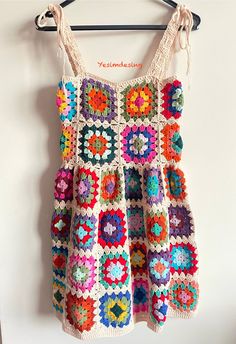 a crocheted dress hanging on a wall