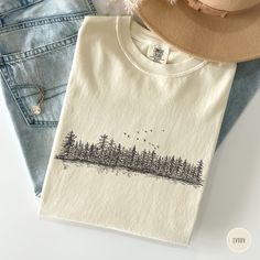 Embrace your adventurous spirit with this Comfort Colors t-shirt featuring a graphic of pine trees. Perfect for nature lovers and granola girls, this wilderness-inspired shirt is an ideal gift for campers, hikers, and those who love to explore and enjoy bonfires. Prefer this design on a Sweatshirt? Visit this link: https://bohemianbloomdesigns.etsy.com/listing/1756263663 👕 T-Shirt Brand Comfort Colors 1717 | Unisex Adult Sizing | 100% Ring-Spun US Cotton ⏳🚚 Production & Shipping All items are Granola Graphic Tees, Long Sleeve Graphic Print T-shirt For Camping, Outdoor Cotton Printed Tops, Printed Cotton Tops For Outdoor, Cotton Screen Print Tops For Outdoor Activities, Cotton Graphic Print Tops For Outdoor Activities, Cotton Graphic Tee For Outdoor, Graphic Print Cotton Top For Outdoor Activities, Outdoor Long Sleeve Cotton Tops