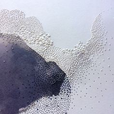 water drops on white paper with black and white image in the middle, as seen from above