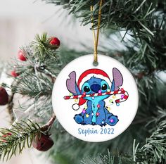 a christmas ornament hanging from a tree with an image of stitch - stitch stitch stitch