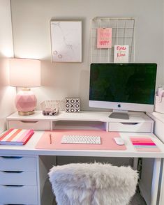 a white desk with a computer on top of it and a pink chair next to it