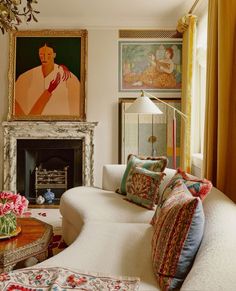 a living room filled with furniture and a painting on the wall over a fire place