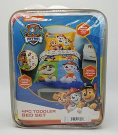 the paw patrol 4 piece toddler bed set is in its plastic case and has four cartoon characters on it