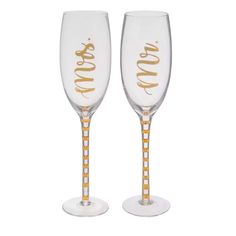 two champagne glasses with gold lettering on them