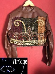 Customized 70s leather jacket.  A cropped 70s jacket, with attached embroidered piece in the back No lining Please check fit carefully. MEASUREMENTS (taken flat) SIZE  marked on item:  Aprox. modern size:  SHOULDER : 13cm SLEEVE : 59 cm BUST: 45cm LENGTH: 42 cm MATERIAL /F A B R I C : real leather,  semio soft quality leather in the back: attached embroidered with plastic pearls and wood pearls,  woven part COLOR:  caramel brown  CONDITION: fine vintage condition Item not pinned on model. For re 70s Leather Jacket, Vintage Website, Indian Summer Dress, Bohemian Outfits, 70s Jacket, Hippie Jacket, 60s Women, Vintage Dress 70s, 80s And 90s Fashion