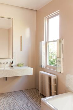 a bath room with a sink a mirror and a radiator