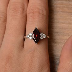 It is a natural garnet ring. The main stone is 7mm*12mm marquise cut, weight about 2.25 carats. The basic metal is sterling silver and plated with rhodium. To change the metal to a solid gold (white/rose) or platinum is also available, please ask for a quotation if you want. You can also go to my shop Home for more elegant rings: https://www.etsy.com/shop/godjewelry?ref=hdr_shop_menu More garnet rings: https://www.etsy.com/shop/godjewelry?section_id=20709242 Customization is always welcome and p Silver Marquise Ruby Ring For Anniversary, Ruby Birthstone Ring Marquise Cut For Anniversary, Ruby Marquise Cut Birthstone Ring For Anniversary, Marquise Cut Ruby Birthstone Ring For Anniversary, Anniversary Ruby Birthstone Ring With Marquise Cut, Marquise Garnet Ring For Anniversary, Garnet Gemstone Ring In Marquise Cut, Marquise Cut Garnet Gemstone Ring, Silver Solitaire Engagement Ring