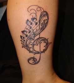 a tattoo with musical notes on it's leg and the word music written in cursive writing