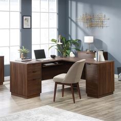 an office desk with a chair and laptop on it