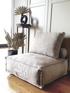 a chair that is sitting on the floor next to a plant