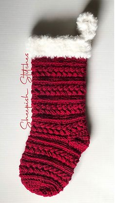 a red and white knitted stocking hanging on a wall with the words happy christmas written below it