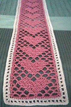 a crocheted pink and white ribbon on a table