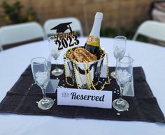 a table topped with wine glasses and a bottle of champagne next to a sign that says reserved