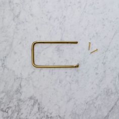 a pair of nails sitting on top of a white marble counter next to a nail holder