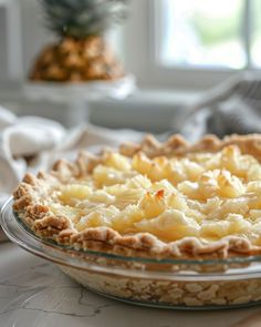 a pie sitting on top of a table next to a pineapple potted plant