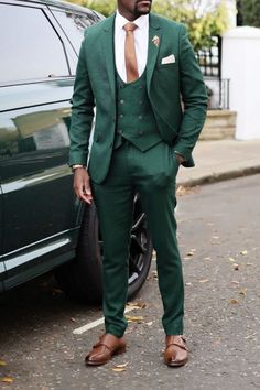 a man in a green suit standing next to a car