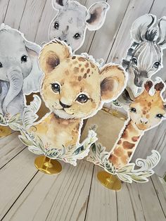 four stickers with different animals on them sitting next to each other in front of a wooden background