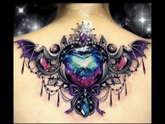 the back of a woman's neck with an intricate tattoo design on her chest