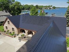 an aerial view of a house with a lake in the back ground and boats on the water