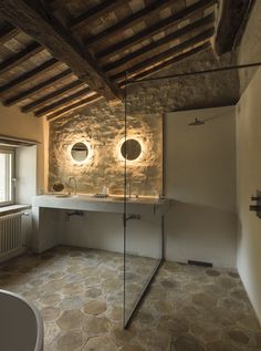 a bathroom with stone walls and exposed ceiling