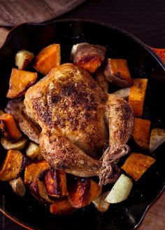 a roasted chicken and vegetables in a cast iron skillet