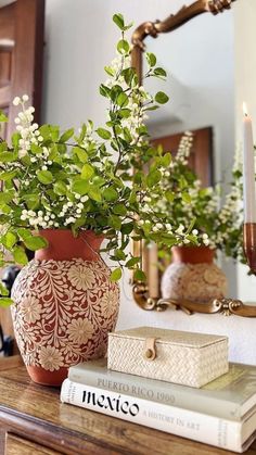 a vase filled with white flowers sitting on top of a table next to a mirror