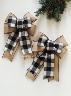 two black and white plaid bows with pine branches in the background