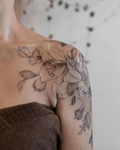 a woman with a flower tattoo on her shoulder