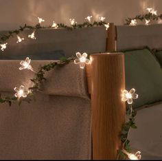 some lights that are on the side of a wooden pole in front of a bed