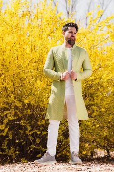 Olive Green Sherwani made with a gorgeous raw silk fabric embroidered with thread and gold sequin. Paired with white straight- leg pants