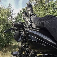 a person sitting on the back of a motorcycle with their feet up in the air